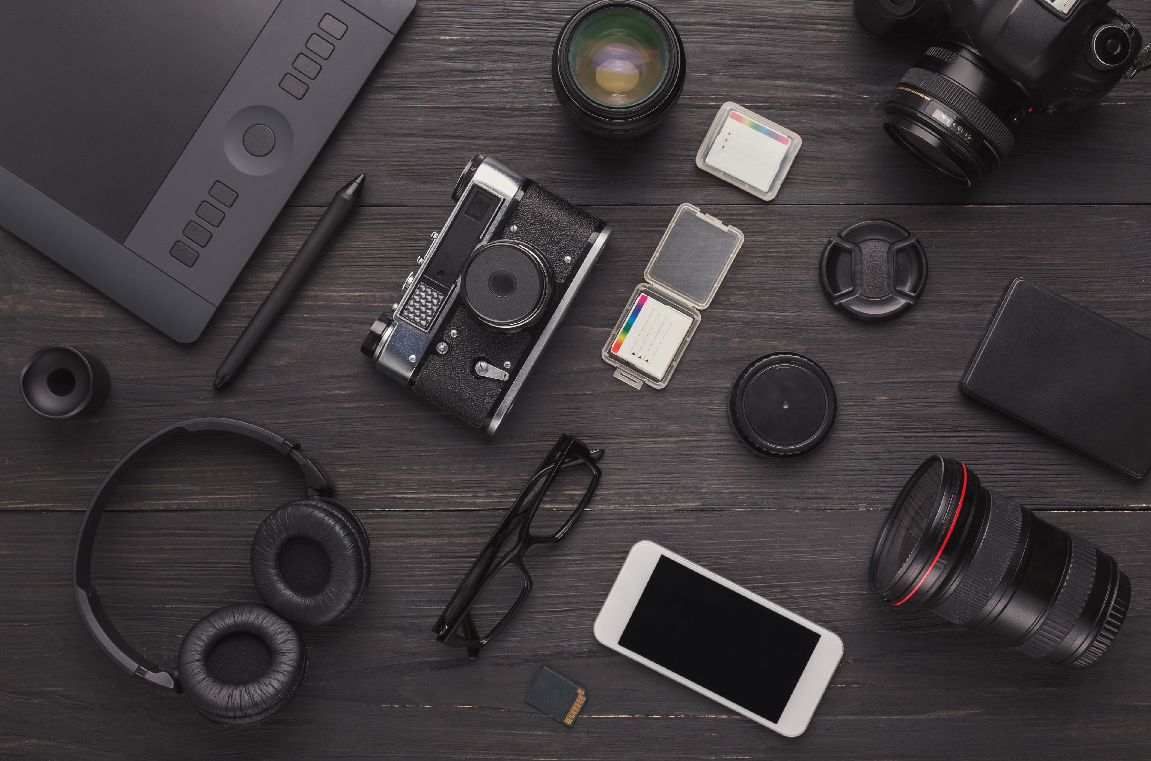 Collection of photography and technology items on a dark wooden surface